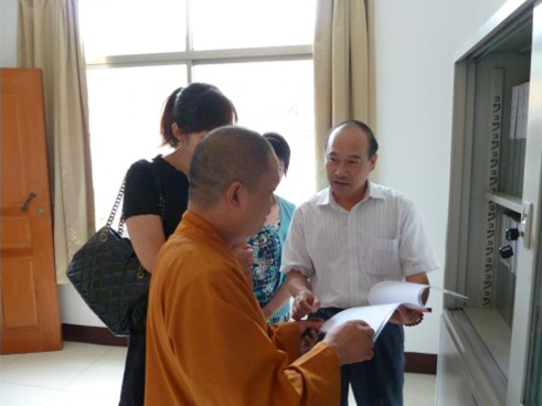 方丈达胜大和尚向档案局领导介绍本寺档案管理的书签标识